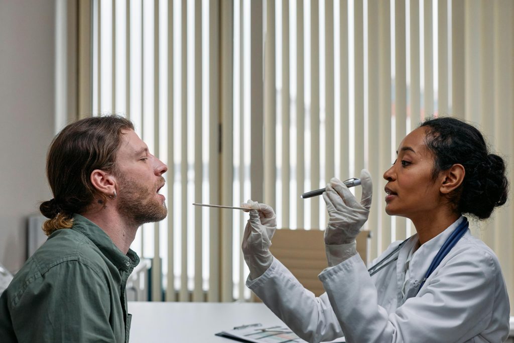 A doctor examining a patient's throat in a clinical setting, highlighting professional healthcare.
